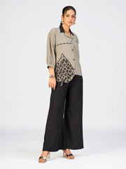 Stylish women’s beige shirt with black collar and decorative applique near the hem.