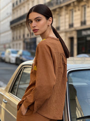 Close-up of embroidery detailing on brown linen women’s shirt