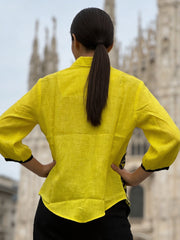 Close-up of black embroidery design on yellow linen shirt