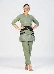 Stylish pink kurti featuring sun, clouds, and landscape embroidery captured in a studio photoshoot.