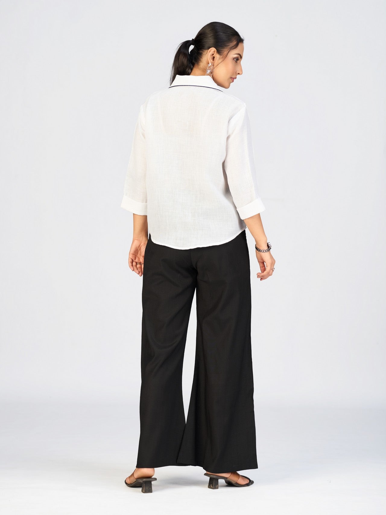 Front view of a model in a white button-down top featuring vibrant sunflower embroidery.