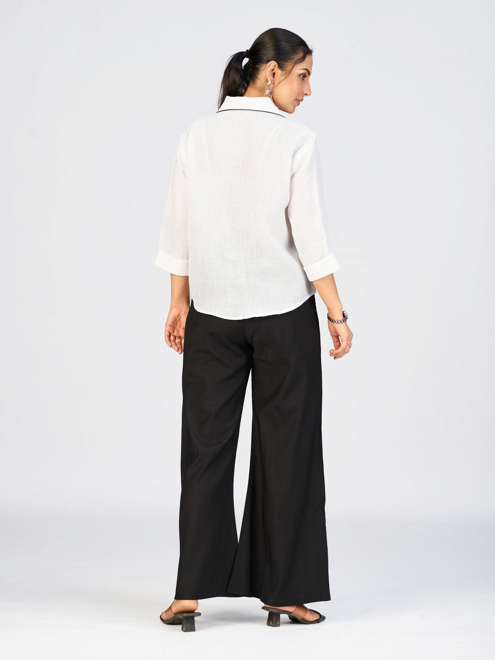 Front view of a model in a white button-down top featuring vibrant sunflower embroidery.