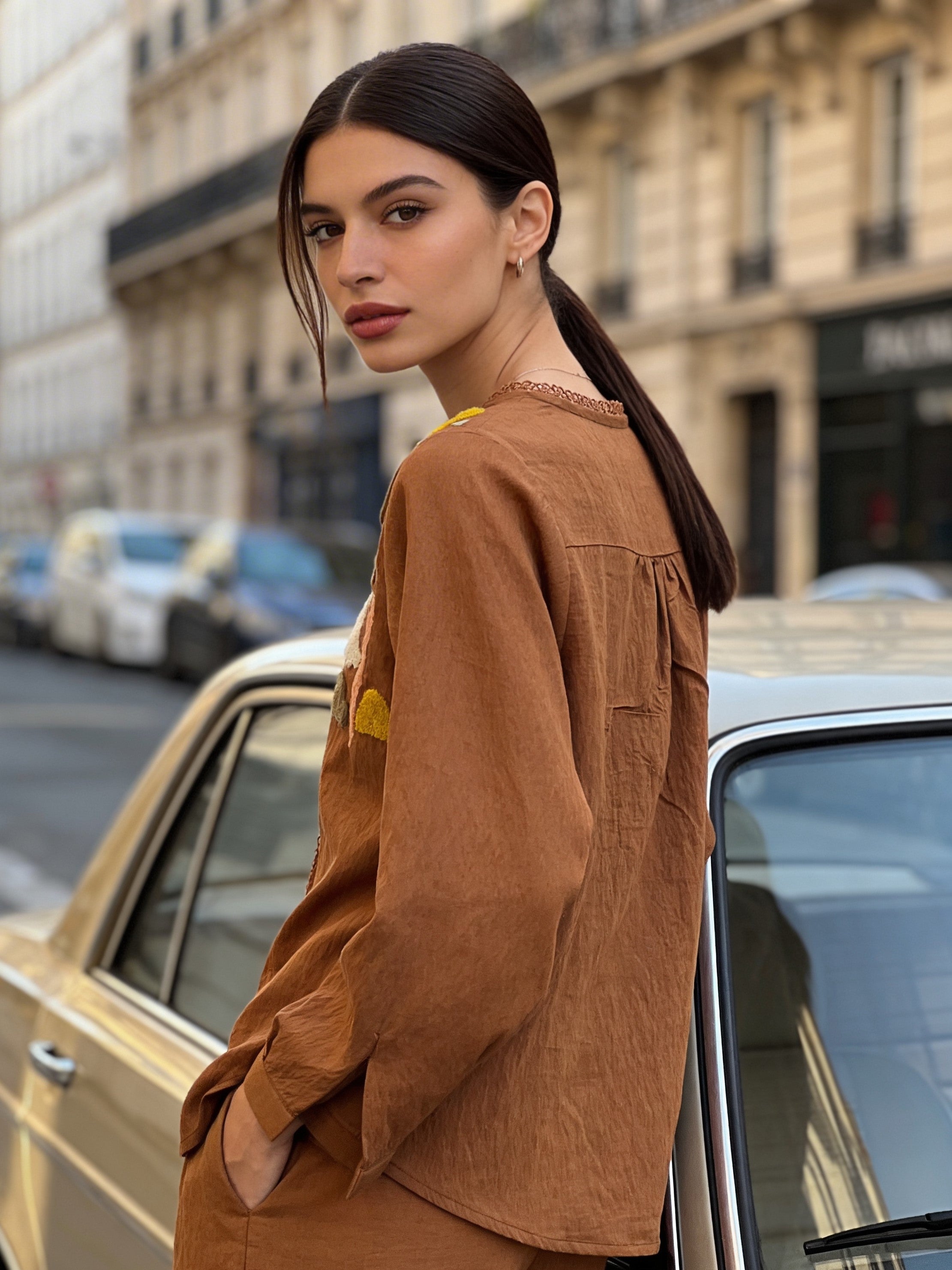 Close-up of embroidery detailing on brown linen women’s shirt
