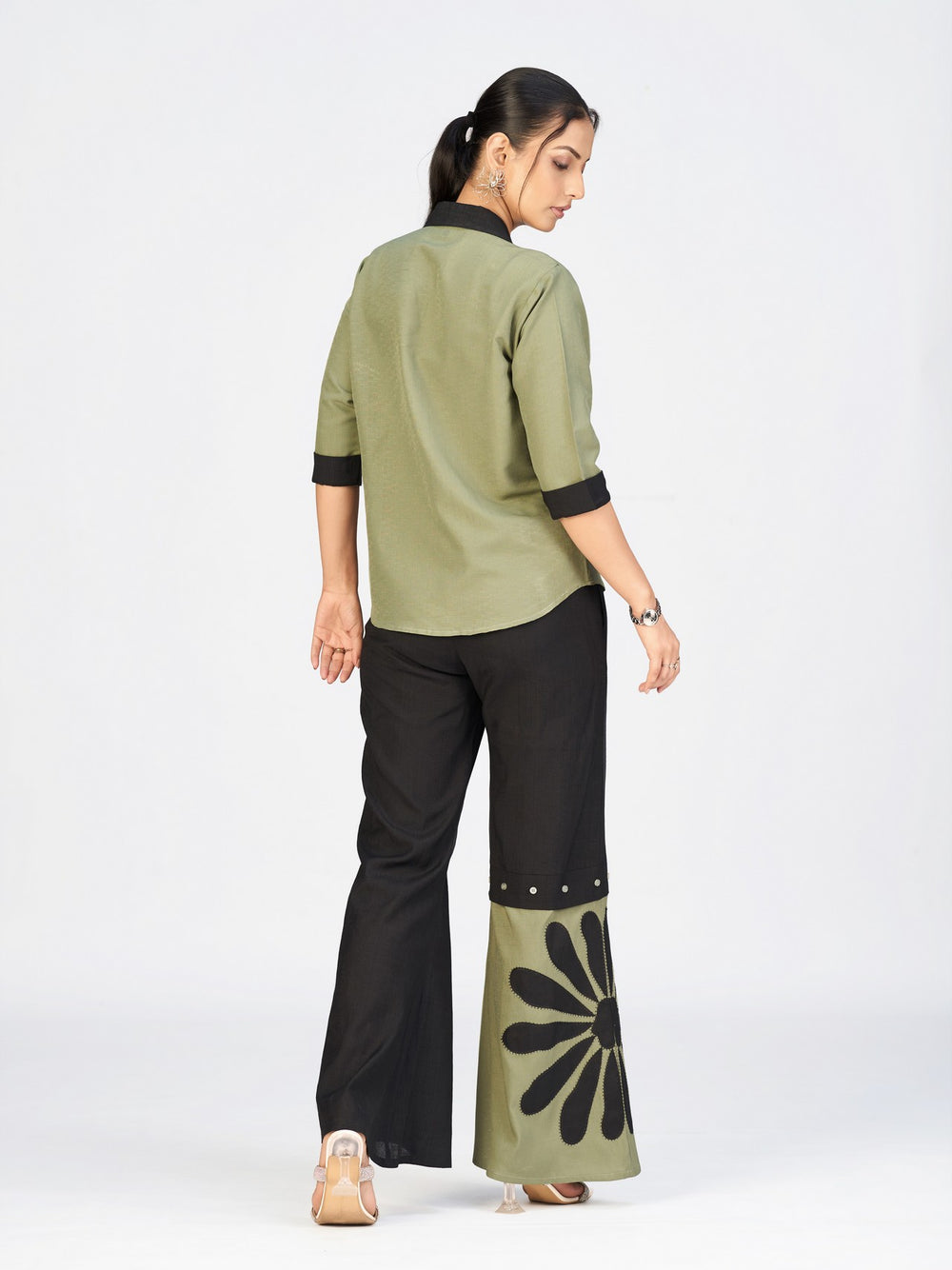 Model standing in a chic printed co-ord ensemble with buttoned shirt and contrast wide-leg pants.