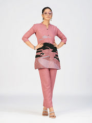 Close-up view of a woman wearing a pink textured kurti with scenic embroidery and button-down front.