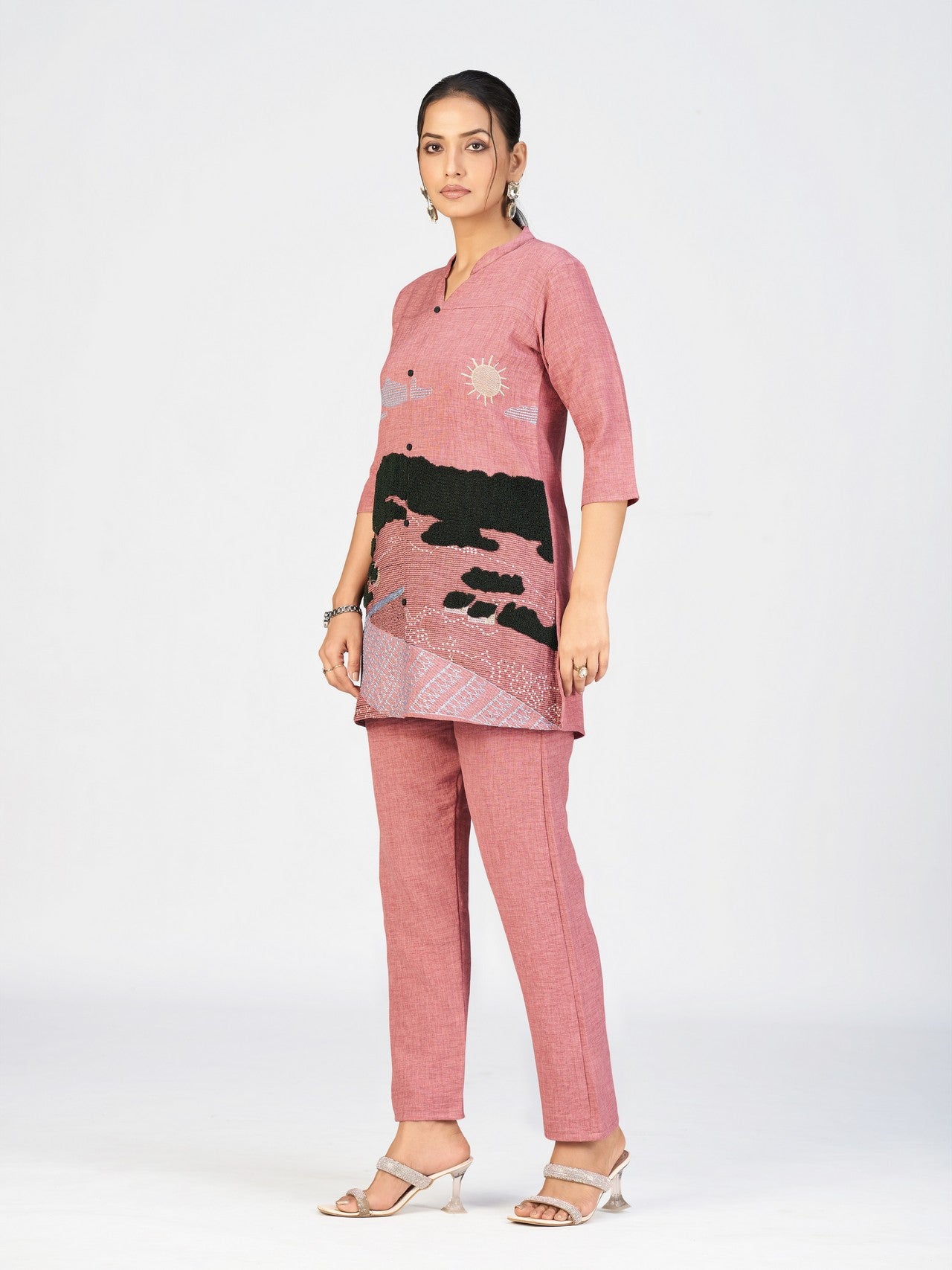 Model showcasing a pink mandarin-collar kurti with artistic embroidered patterns.