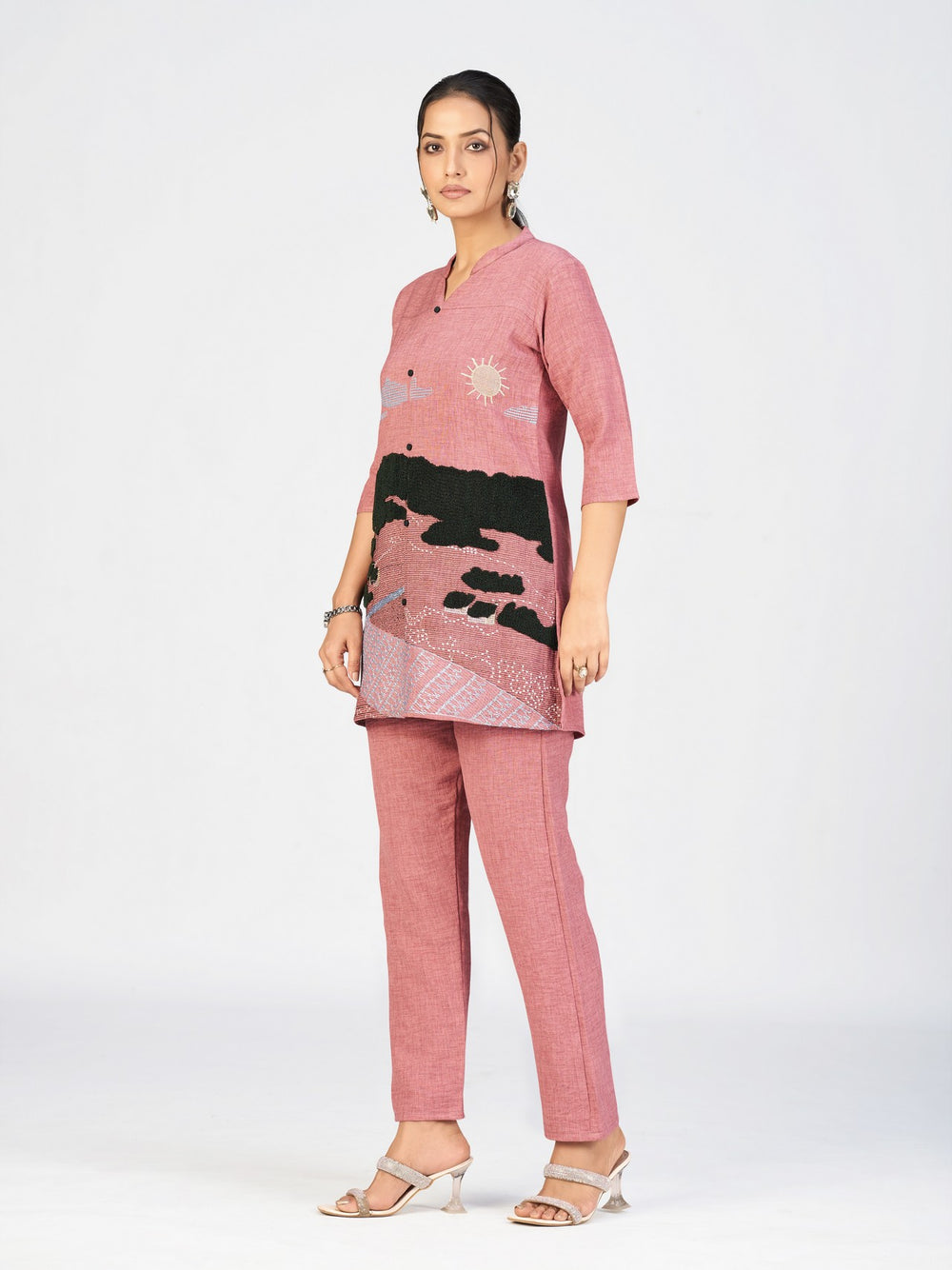 Model showcasing a pink mandarin-collar kurti with artistic embroidered patterns.