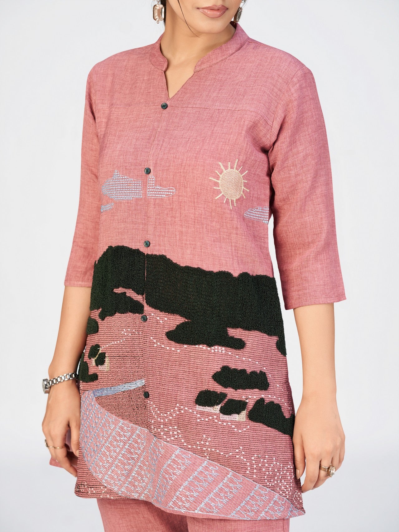 Women’s ethnic kurti in pink with decorative stitching and contrast embroidery details.
